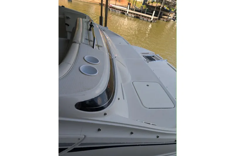 Slide: The Image of 2001 Monterey 248LS Montura Bowrider boat interior with cup holders, docked by the water. - 5