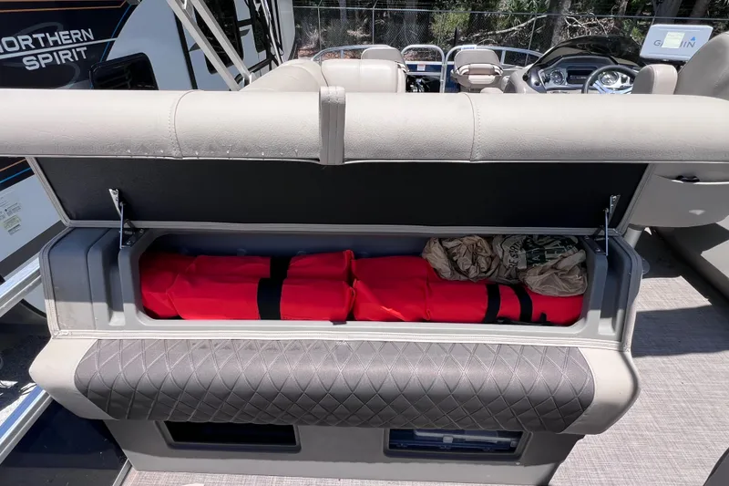 Slide: The Image of Storage compartment on 2023 Sun Tracker Fishin' Barge 22 DLX with life jackets and gear. - 17
