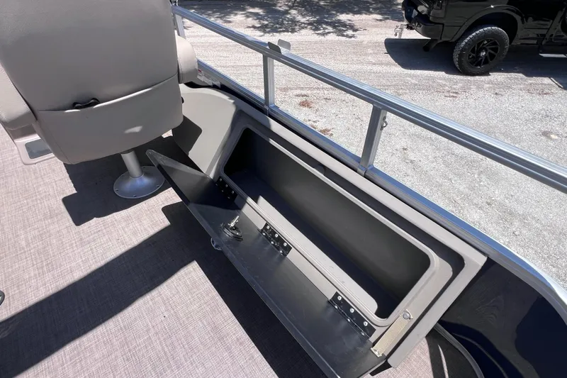 Slide: The Image of 2023 Sun Tracker Fishin' Barge 22 DLX interior storage compartment and seating detail. - 18
