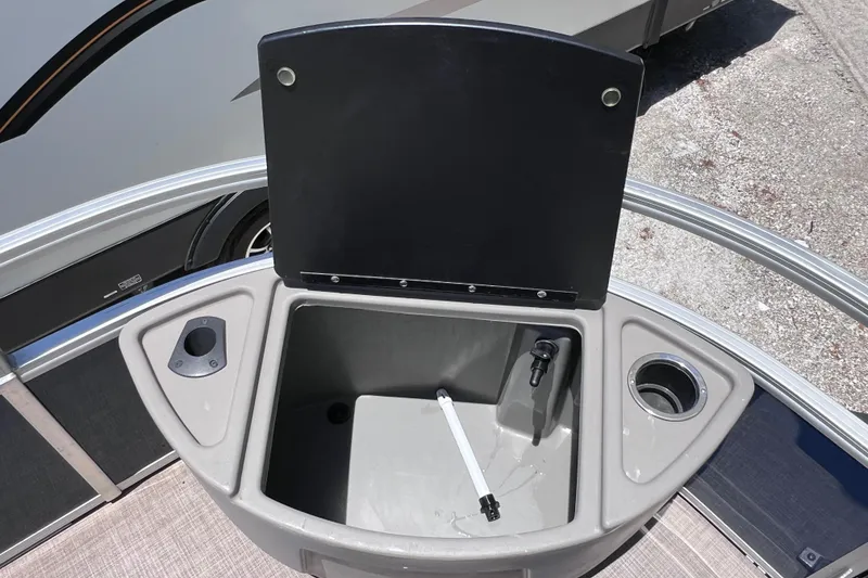 Slide: The Image of 2023 Sun Tracker Fishin' Barge 22 DLX livewell with open lid and cup holders. - 33