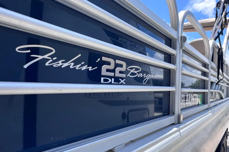 Slide: The Image of 2023 Sun Tracker Fishin' Barge 22 DLX pontoon boat, side view with logo. - 8