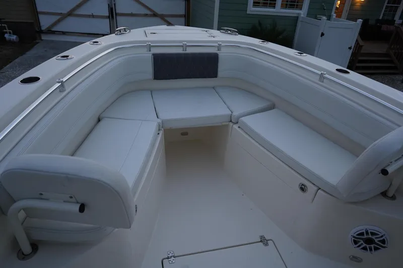 Slide: The Image of 2022 Cobia 266 boat interior with white cushioned seating and storage compartments. - 16