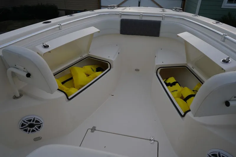 Slide: The Image of 2022 Cobia 266 boat interior with open storage compartments and life jackets. - 19