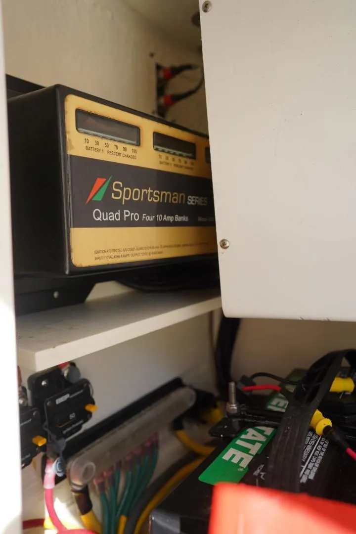 Slide: The Image of Battery charger and wiring inside a 2022 Cobia 266 boat compartment. - 30