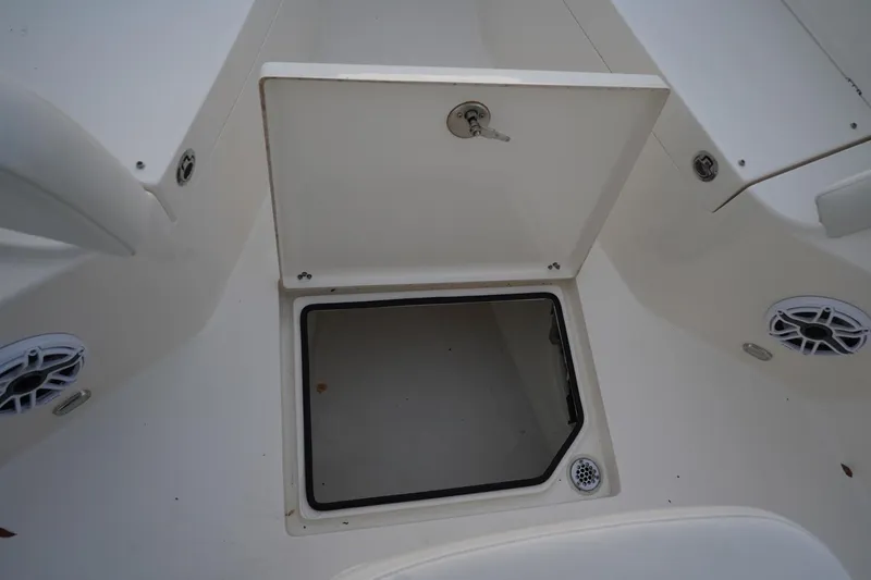 Slide: The Image of 2022 Cobia 266 boat storage compartment with open hatch and speakers. - 44
