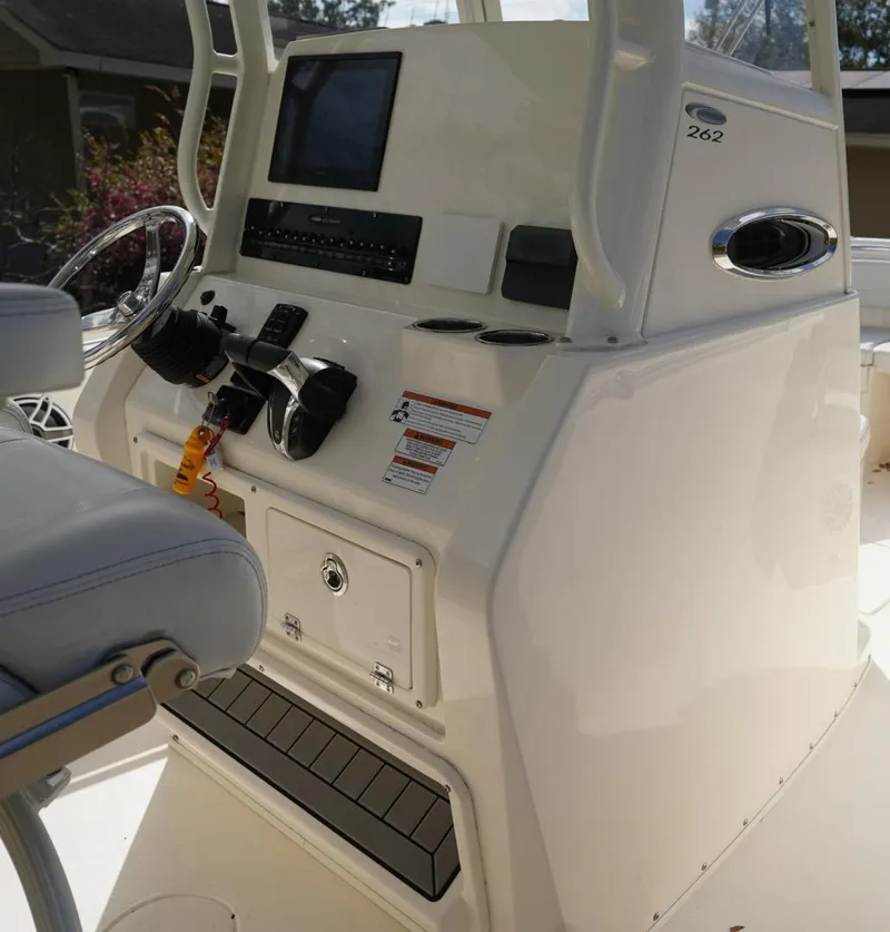 Slide: The Image of 2022 Cobia 266 boat console with steering wheel and electronic controls. - 9