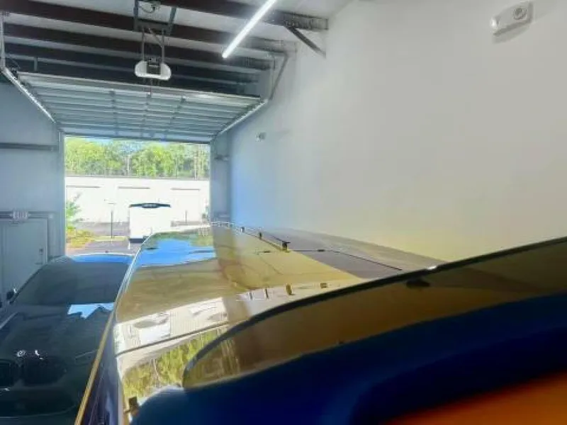 Slide: The Image of 2005 Cigarette 39 Top Gun boat in a garage, partially visible with open door. - 16
