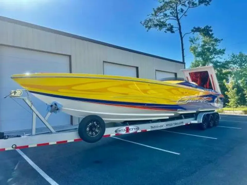 Slide: The Image of 2005 Cigarette 39 Top Gun speedboat on trailer, vibrant yellow and blue design. - 2