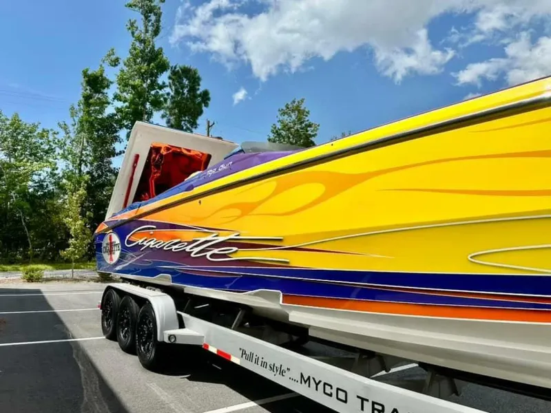 Slide: The Image of 2005 Cigarette 39 Top Gun speedboat with vibrant yellow and orange design on trailer. - 5