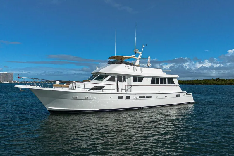 The Image of 1989 Hatteras Custom Cockpit yacht on calm water under clear blue sky. - 2