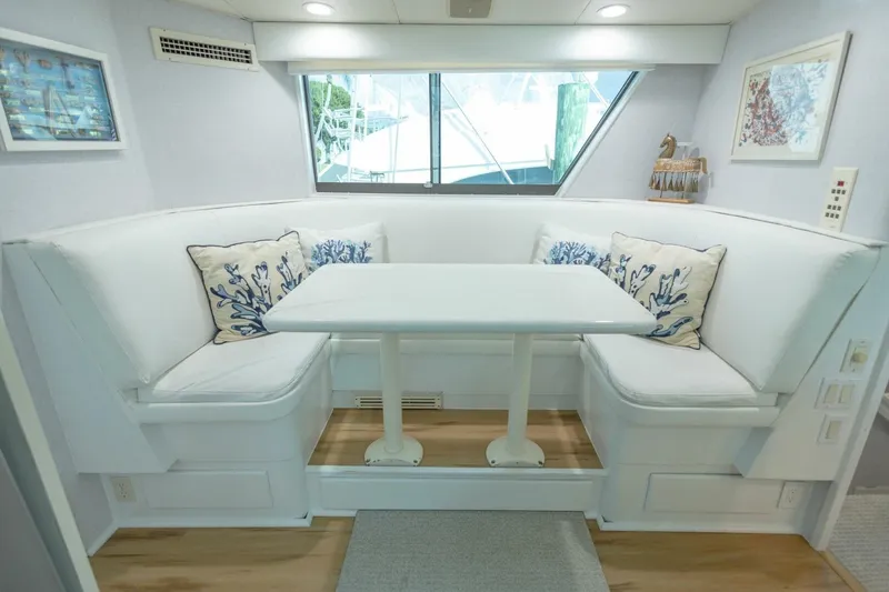 Slide: The Image of 1989 Hatteras Custom Cockpit interior with white seating, nautical decor, and large window. - 20