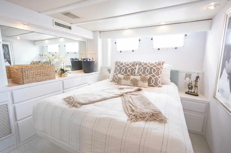 Slide: The Image of Luxurious 1989 Hatteras Custom Cockpit yacht bedroom with elegant decor and natural light. - 34