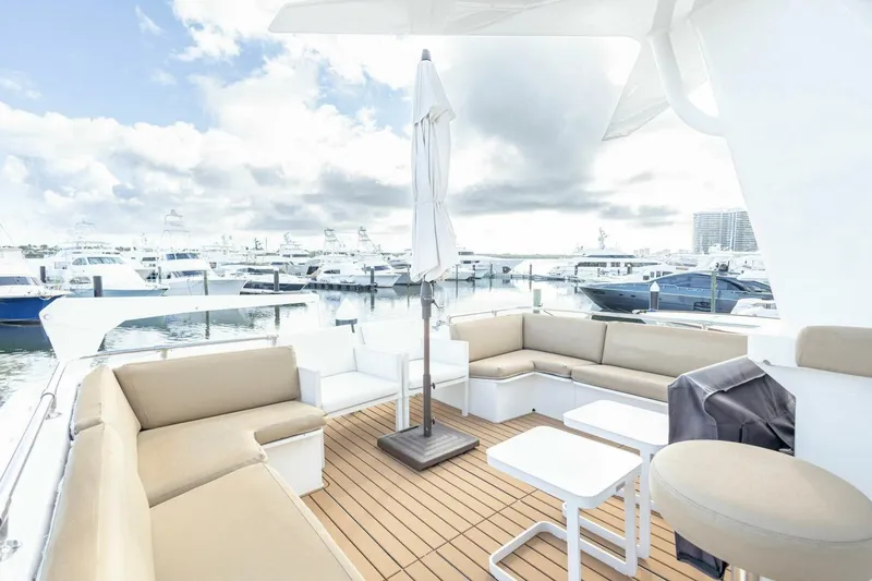 Slide: The Image of 1989 Hatteras Custom Cockpit yacht with spacious seating, docked at a marina under cloudy skies. - 47