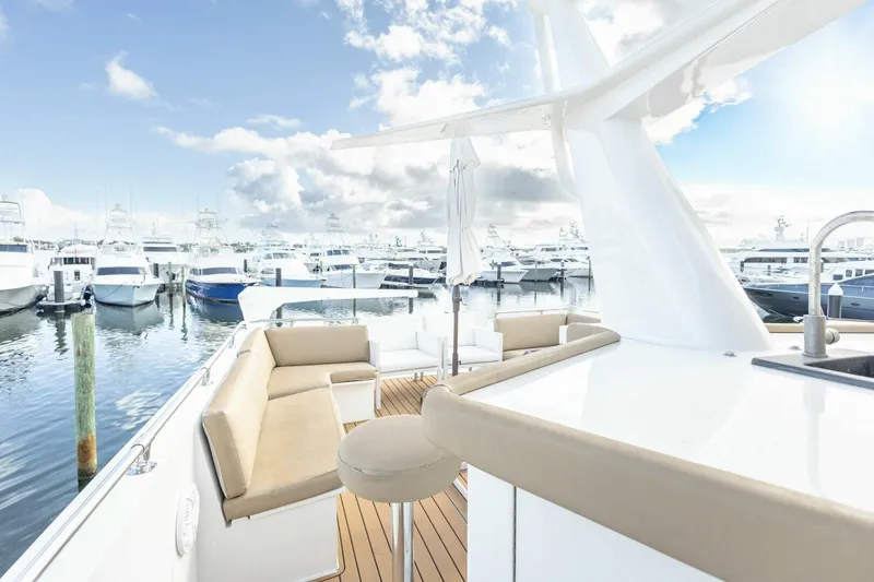 Slide: The Image of 1989 Hatteras Custom Cockpit yacht with elegant seating, docked in a marina under a bright sky. - 51