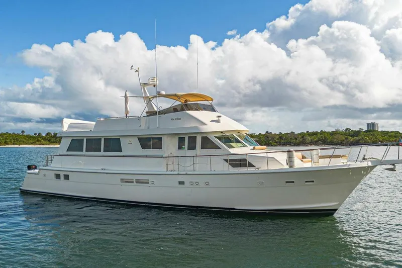 Slide: The Image of 1989 Hatteras Custom Cockpit yacht on calm water under a partly cloudy sky. - 7
