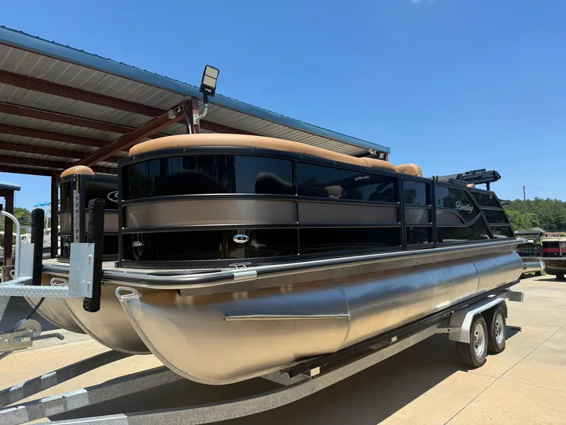 Slide: The Image of 2026 Bentley Pontoons Legacy 223 Swingback on trailer under canopy. - 1