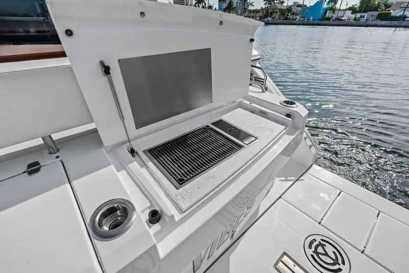 Slide: The Image of Outdoor grill on 2022 Cruisers Yachts 46 Cantius, docked by the water. - 16