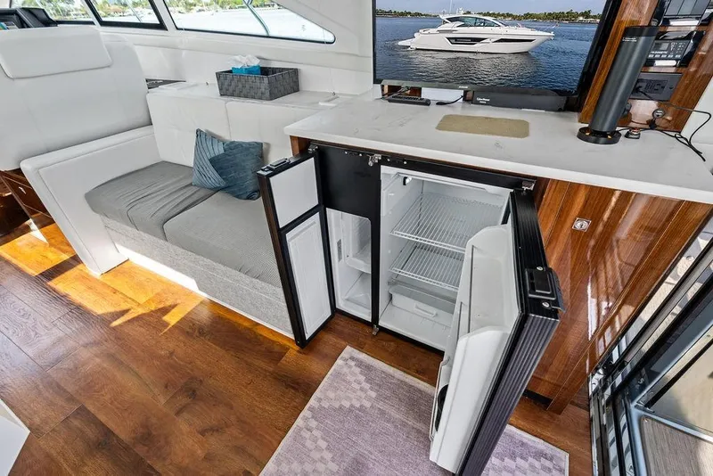Slide: The Image of Interior of 2022 Cruisers Yachts 46 Cantius with open fridge and seating area. - 25