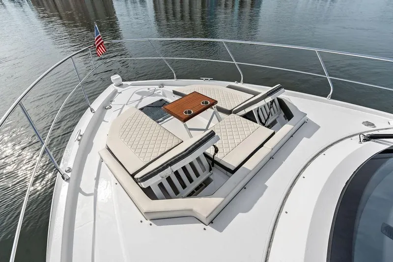 Slide: The Image of Luxurious 2022 Cruisers Yachts 46 Cantius with elegant bow seating and table on calm waters. - 8