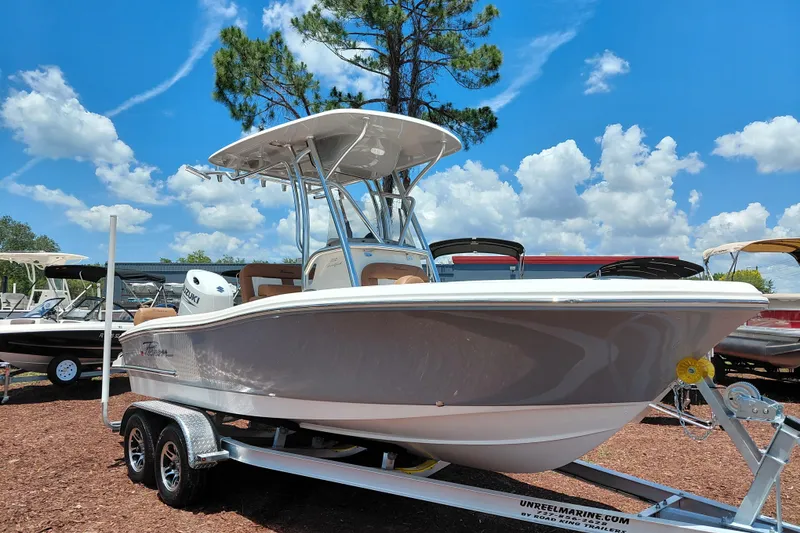 The Image of 2026 Pioneer 202 Sportfish boat on trailer under clear blue sky. - 1