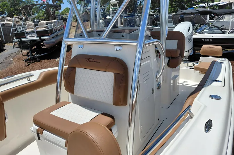 Slide: The Image of 2026 Pioneer 202 Sportfish boat interior with tan and white seating, stainless steel accents. - 16