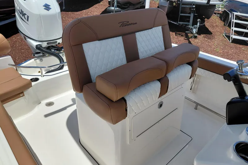 Slide: The Image of 2026 Pioneer 202 Sportfish boat interior with cushioned seating and Suzuki engine. - 25