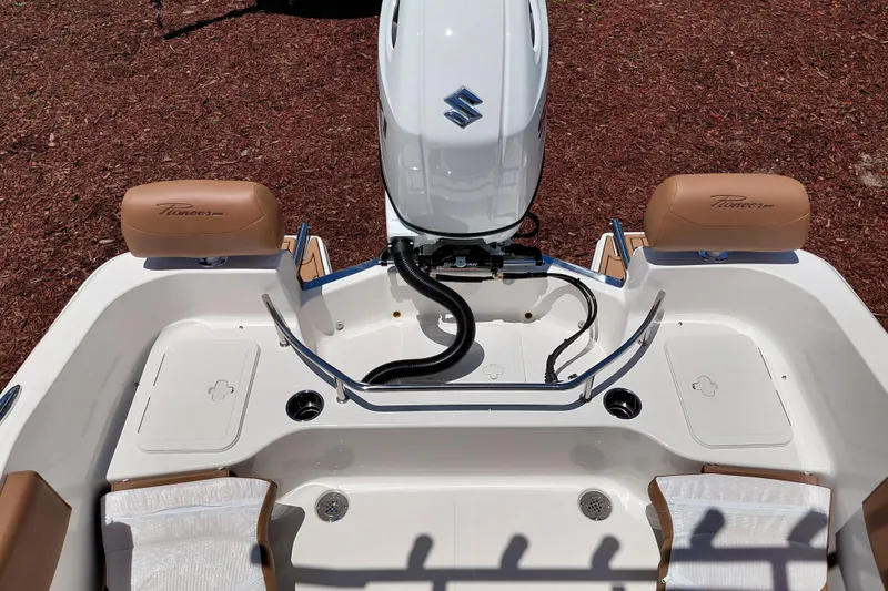 Slide: The Image of 2026 Pioneer 202 Sportfish boat interior with Suzuki engine, tan seating, and storage compartments. - 32
