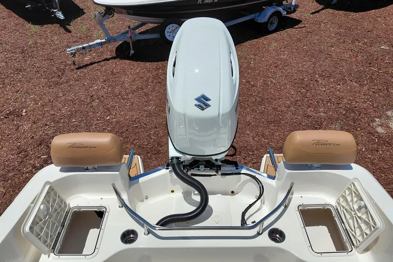 Slide: The Image of 2026 Pioneer 202 Sportfish boat with Suzuki outboard motor, featuring tan seating and storage compartments. - 33