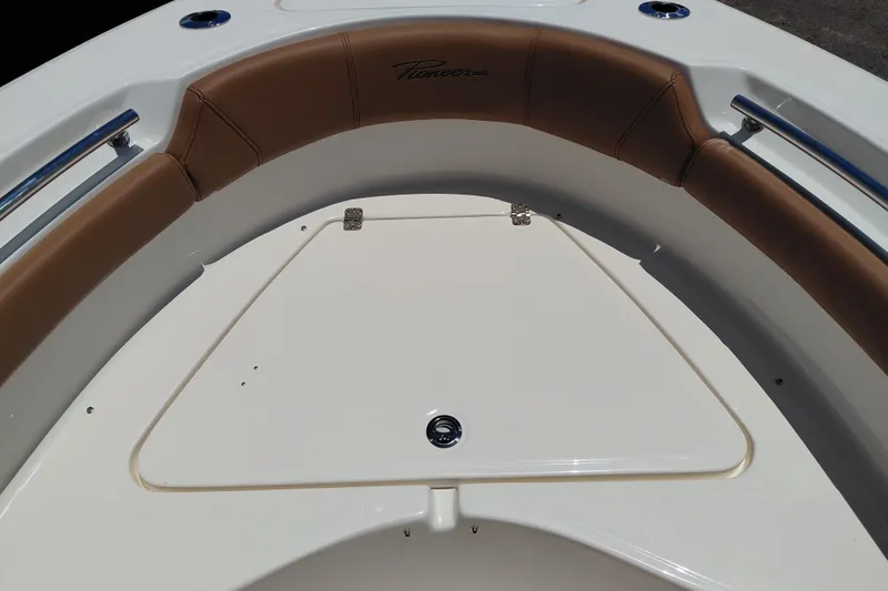 Slide: The Image of 2026 Pioneer 202 Sportfish boat interior with cushioned seating and storage compartment. - 37