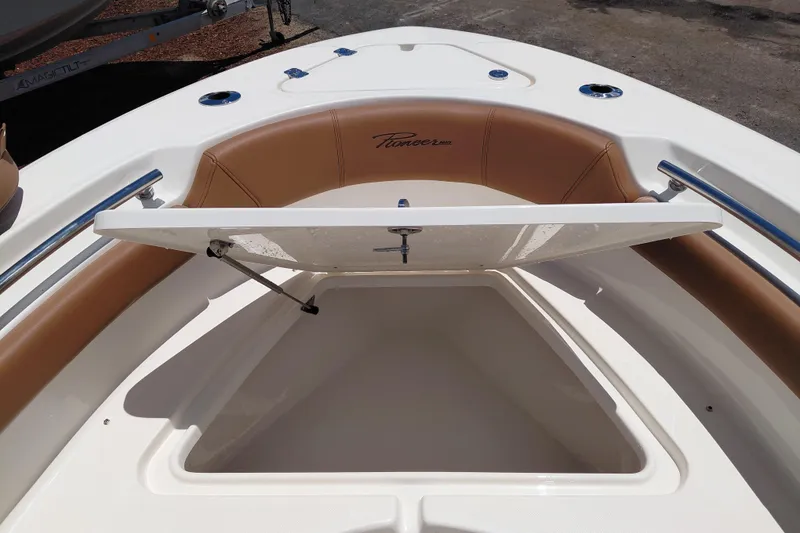 Slide: The Image of 2026 Pioneer 202 Sportfish boat with open storage compartment and cushioned seating. - 38
