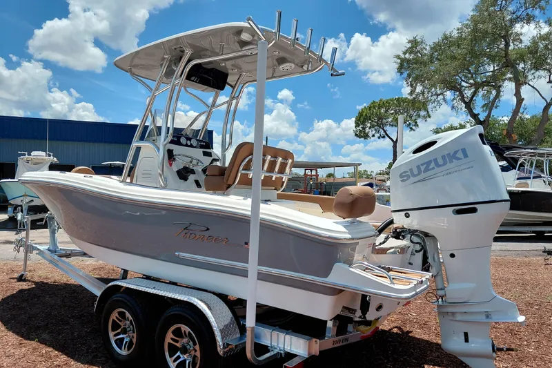 Slide: The Image of 2026 Pioneer 202 Sportfish boat with Suzuki engine on a trailer, outdoors under blue sky. - 5