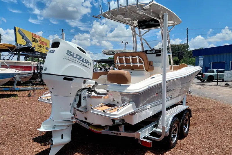 Slide: The Image of 2026 Pioneer 202 Sportfish boat with Suzuki engine on a trailer, outdoor display. - 7