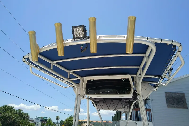 Slide: The Image of T-top of 2003 Wellcraft 250 Fisherman boat with rod holders and light. - 14