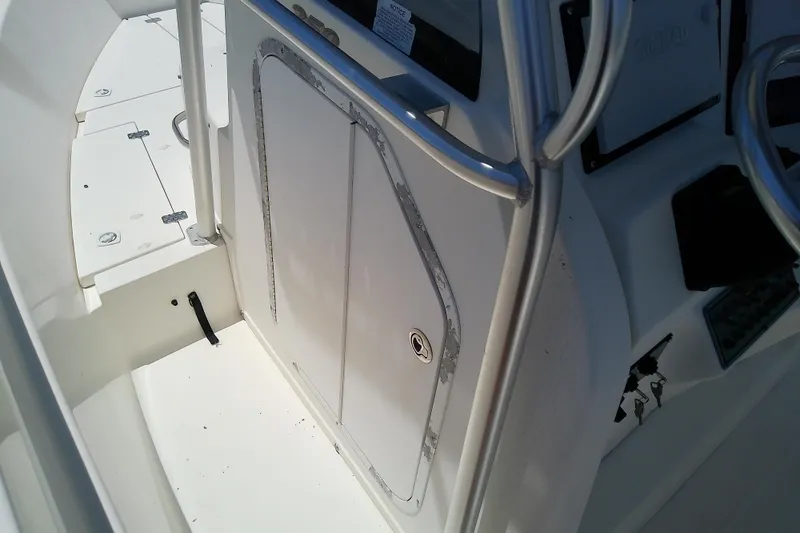 Slide: The Image of 2003 Wellcraft 250 Fisherman boat interior, featuring steering console and storage compartment. - 30