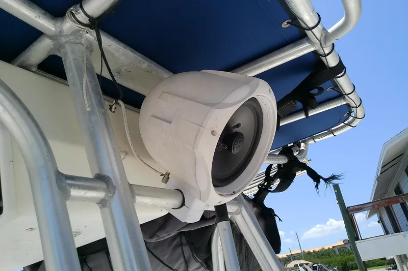Slide: The Image of Speaker mounted on a 2003 Wellcraft 250 Fisherman boat's metal frame under blue canopy. - 32