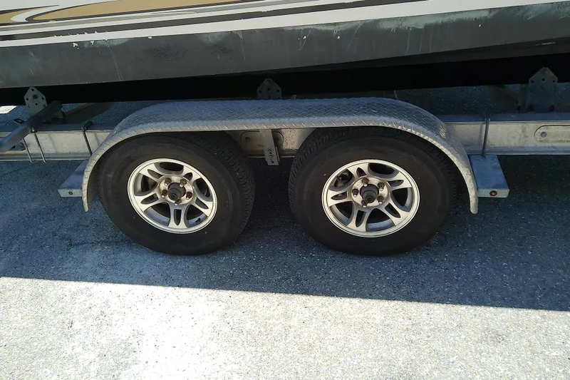 Slide: The Image of Trailer wheels of a 2003 Wellcraft 250 Fisherman boat on asphalt surface. - 8