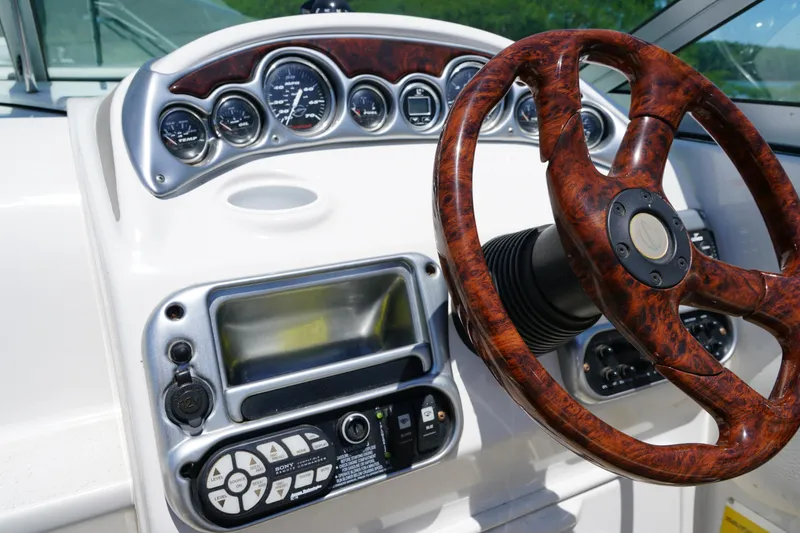 Slide: The Image of Dashboard of a 2004 Crownline 250 CR boat with woodgrain steering wheel. - 12