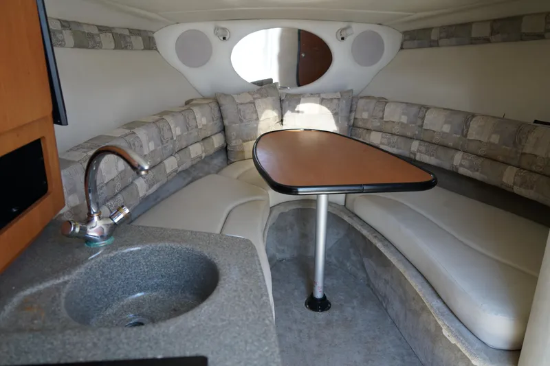 Slide: The Image of 2004 Crownline 250 CR boat interior with seating, table, and sink. - 17