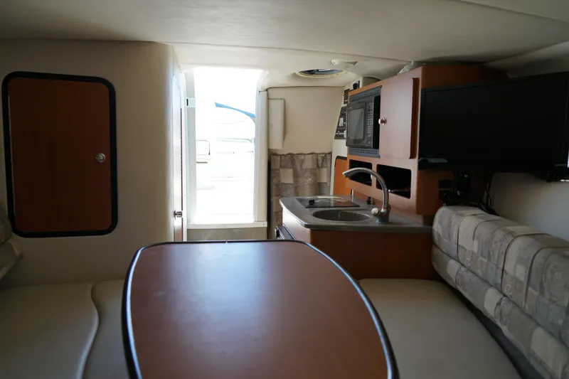 Slide: The Image of Interior of 2004 Crownline 250 CR boat with kitchenette and seating area. - 20