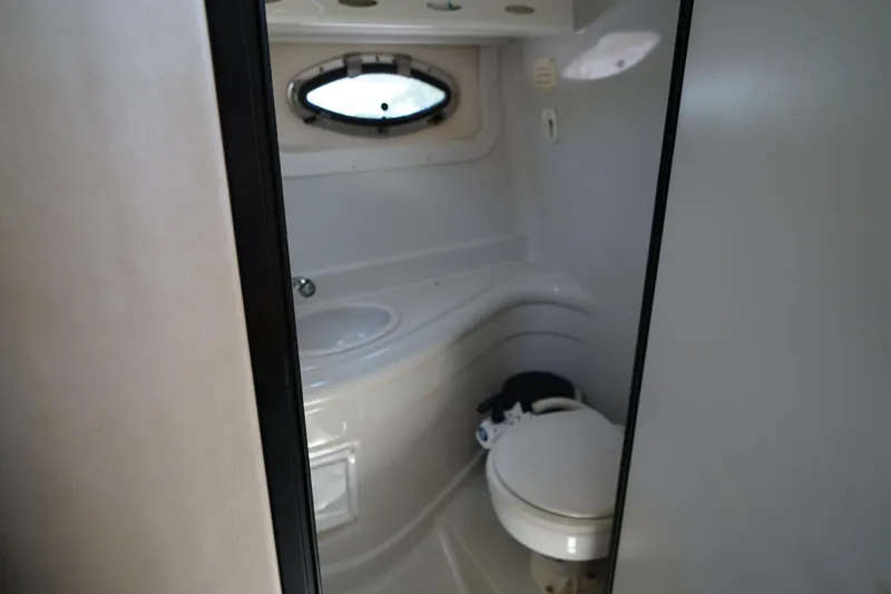 Slide: The Image of 2004 Crownline 250 CR boat bathroom with toilet and sink. - 24