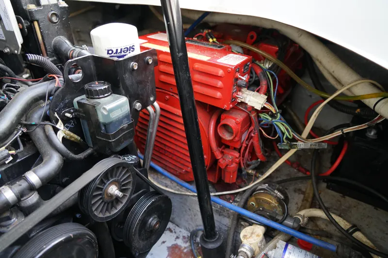 Slide: The Image of Engine compartment of a 2004 Crownline 250 CR boat, featuring red components and wiring. - 26