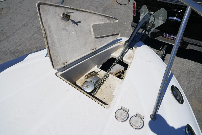 Slide: The Image of Open anchor compartment on 2004 Crownline 250 CR boat, showing chain and winch. - 27