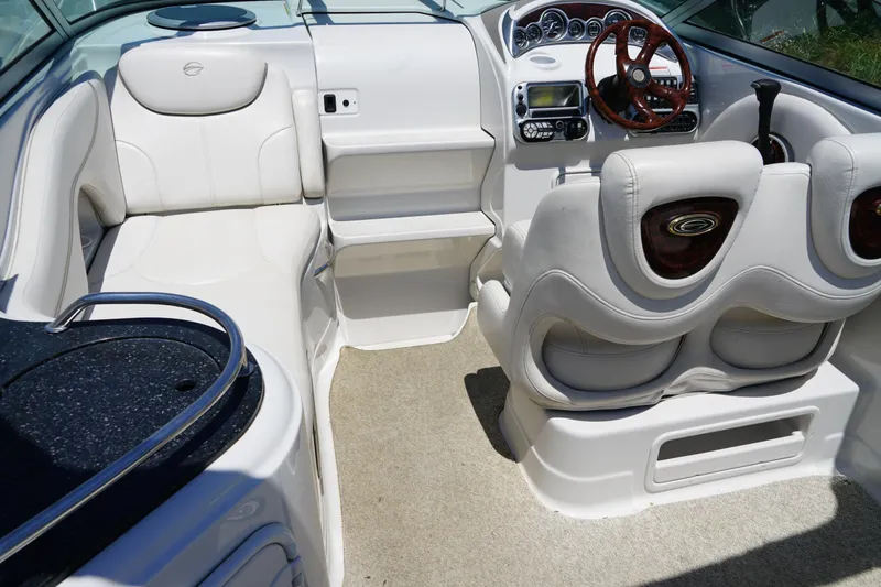Slide: The Image of 2004 Crownline 250 CR boat interior with white seating and modern dashboard. - 9