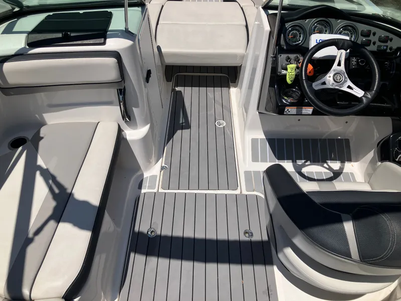 Slide: The Image of Interior of a 2016 Yamaha Boats 212X with gray seating and steering wheel. - 10
