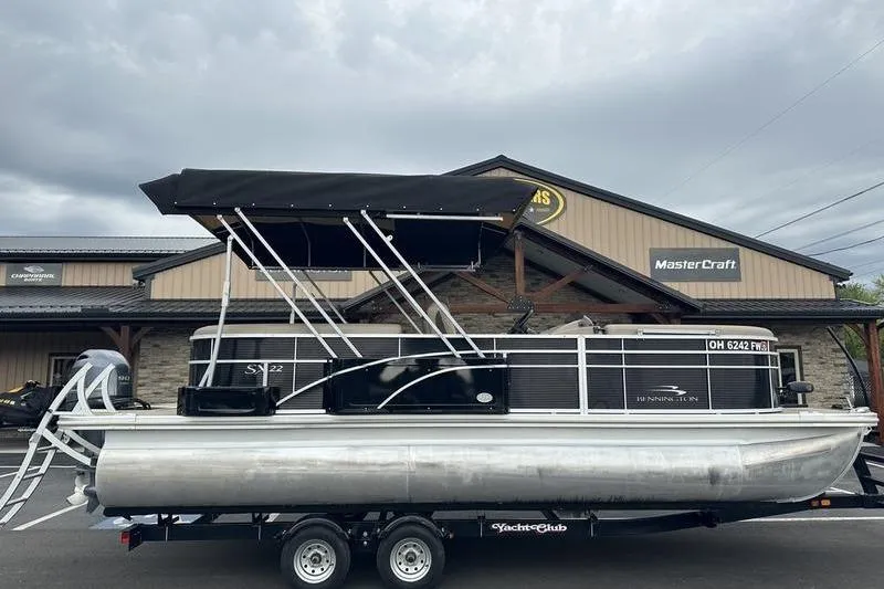 Slide: The Image of 2021 Bennington 20 SSRX pontoon boat on trailer, parked outside dealership. - 13
