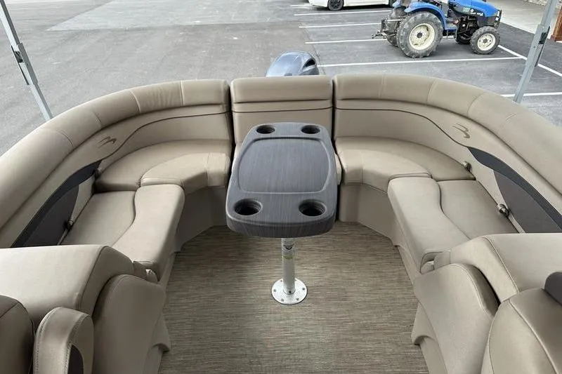Slide: The Image of 2021 Bennington 20 SSRX boat interior with beige seating and central table. - 9