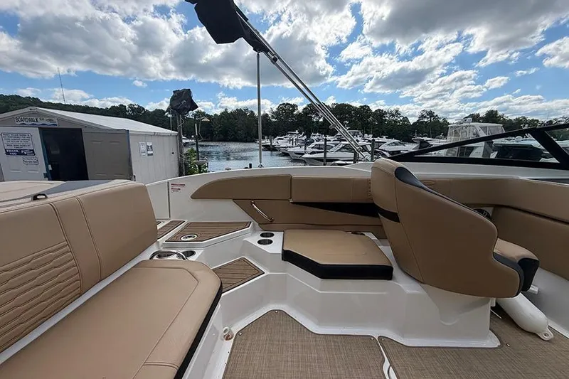 Slide: The Image of Interior of 2021 Sea Ray SPX 210 boat with tan seating, docked at marina. - 12