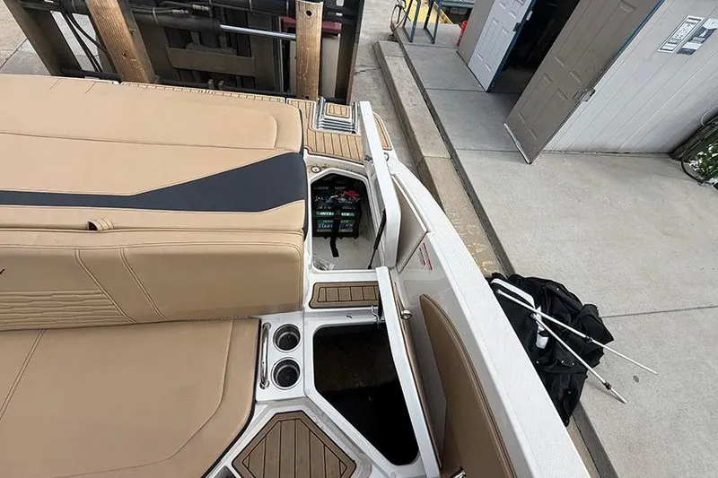 Slide: The Image of 2021 Sea Ray SPX 210 boat interior with tan seating and storage compartments. - 13