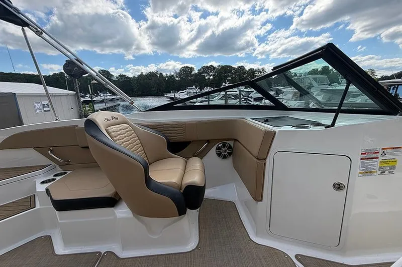 Slide: The Image of Interior view of 2021 Sea Ray SPX 210 boat with tan seating and sleek dashboard. - 19