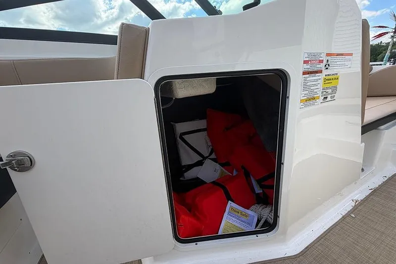 Slide: The Image of Storage compartment on a 2021 Sea Ray SPX 210 boat with life jackets inside. - 21